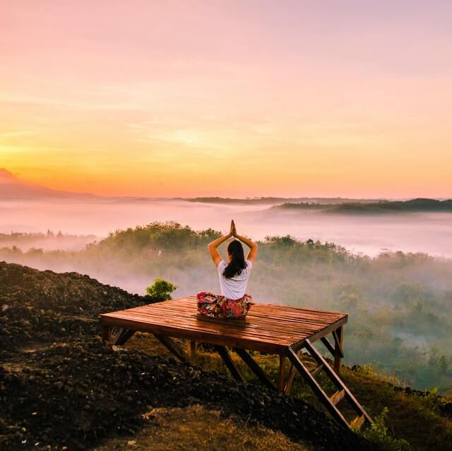 woman meditating on dock