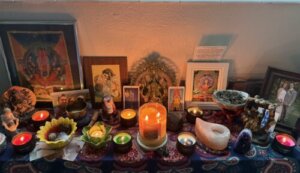 Meditation altar with candles, statues, and pictures