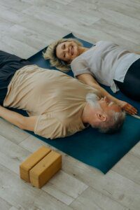 Older couple laughing on yoga mats