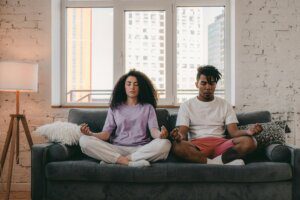 Couple meditating on couch together