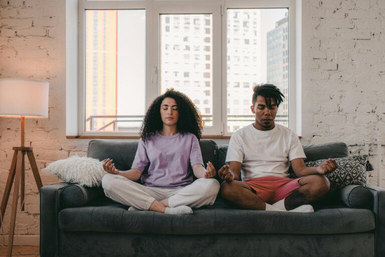 Couple meditating on couch together
