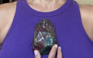 Colorful rock against woman’s heart center